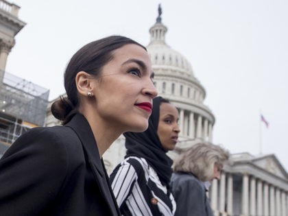 Rep. Alexandria Ocasio-Cortez, left, and D-N.Y., Rep. Ilhan Omar, D-Minn., center, walk down the House steps to take a group photograph of the House Democratic women members of the 116th Congress on the East Front Capitol Plaza on Capitol Hill in Washington, Friday, Jan. 4, 2019, as the 116th Congress …