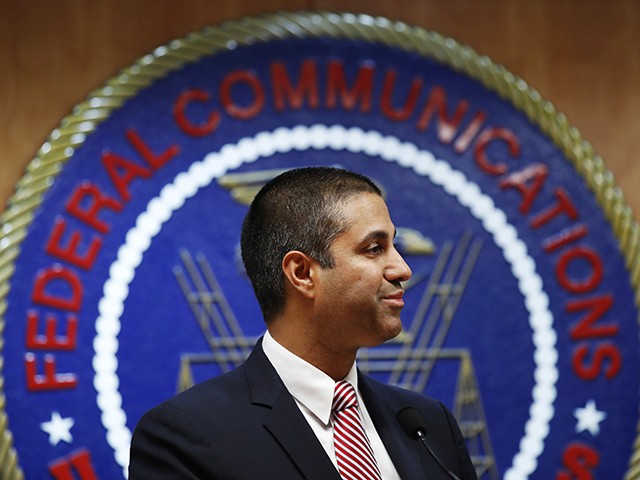 FILE - In this Dec. 14, 2017, file photo, after a meeting voting to end net neutrality, Federal Communications Commission (FCC) Chairman Ajit Pai smiles while listening to a question from a reporter in Washington. A federal court is ruling that the FCC had the right to dump net-neutrality rules, but couldn't bar states like California from passing their own. The ruling is largely a victory for Pai. (AP Photo/Jacquelyn Martin, File)