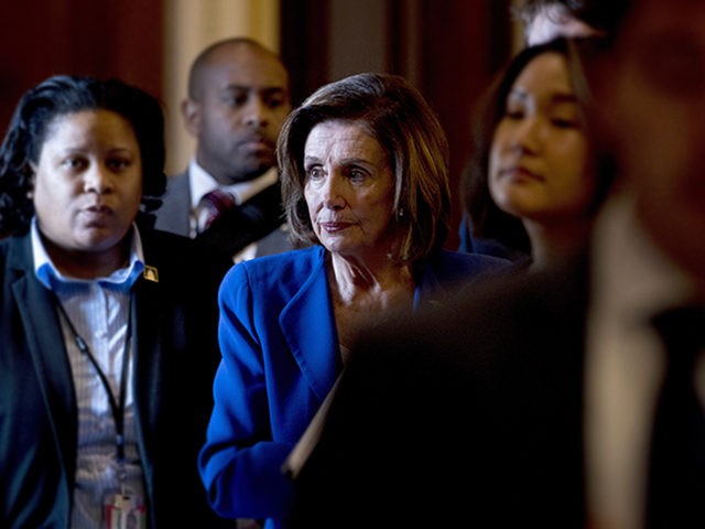 House Speaker Nancy Pelosi of Calif., walks to her office after signing the Coronavirus Ai