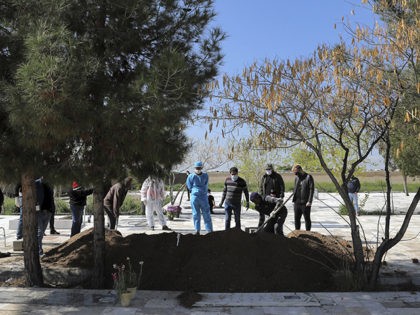 People wearing protective clothings, masks and gloves attend a funeral of a victim who died after being infected with the new coronavirus, at a cemetery just outside Tehran, Iran, Monday, March 30, 2020. The new coronavirus causes mild or moderate symptoms for most people, but for some, especially older adults …