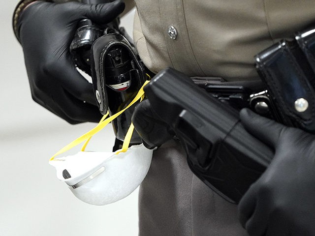 A face mask hangs off the belt of a Texas Department of Public Safety Trooper while workin