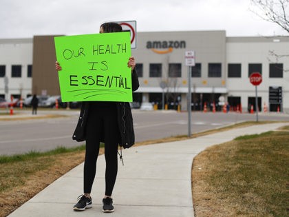 A family member of an employee holds a sign outside the Amazon DTW1 fulfillment center in