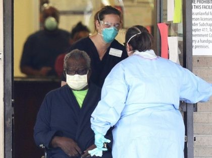 A resident is removed from the Southeast Nursing and Rehabilitation Center in San Antonio, Wednesday, April 1, 2020. At least 12 people at the nursing home have been infected with the coronavirus, including one resident who died, authorities said Wednesday. (AP Photo/Eric Gay)