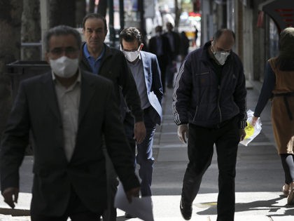 People wearing face masks to protect against the new coronavirus walk on a sidewalk in northern Tehran, Iran, Saturday, April 4, 2020. In the first working day after Iranian New Year holidays authorities have allowed some government offices and businesses to re-open with limited working hours, when schools, universities, and …