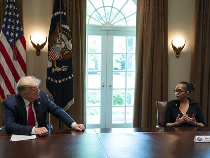 President Donald Trump listens as Karen Whitsett shares her story of recovery from COVID-19, in the Cabinet Room of the White House, Tuesday, April 14, 2020, in Washington. (AP Photo/Evan Vucci)