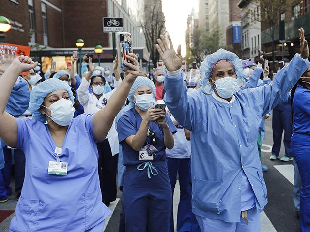 Nurses and medical workers react as police officers and pedestrians cheer them outside Len