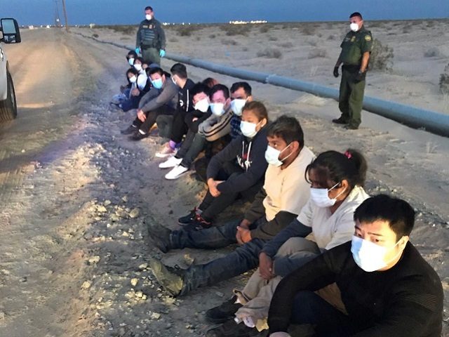 Border Patrol agents wearing masks provide PPE to apprehended migrants. (File Photo: U.S. Border Patrol)