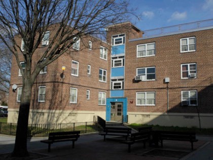 An unidentified woman walks in front of a Breukelen Houses building where the mother of tw