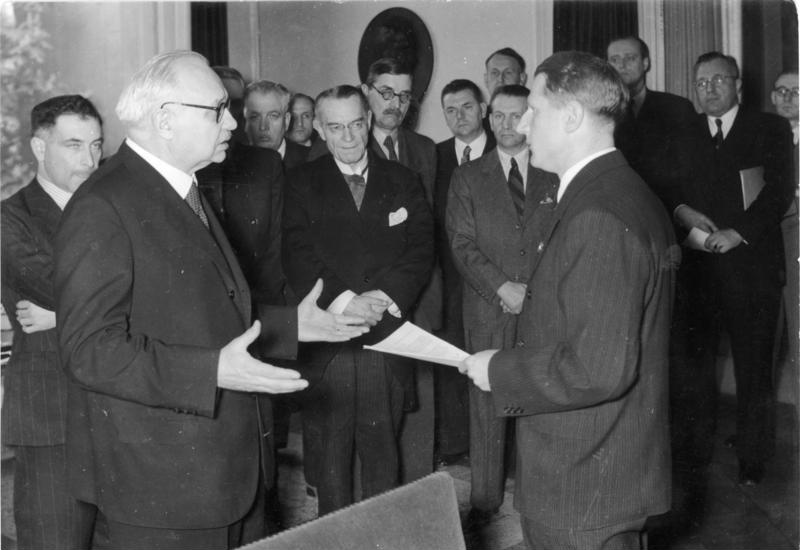 The Third Reich Health Leader Leonardo Conti (right) holds the Report of the International Katyn Commission, 4 May 1943, in front of Dr. Ferenc Orsós from the University of Budapest. Centre, Professor Louis Speleers of the Ghent University in Belgium. Eduard Miloslavić, Croatian professor of pathology, is the 4th person from left