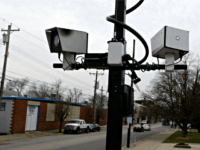 This Wednesday, Jan. 16, 2013 file photo shows a pair of traffic cameras aimed on Vine Street, in Elmwood Place, Ohio. People suing the Cincinnati-area village over speeding tickets generated by a camera system want a judge to rule in their favor without trial, filing a motion for summary judgement …