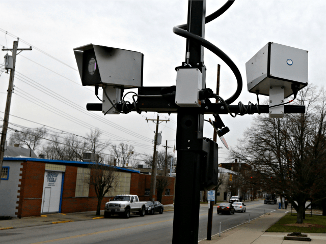 This Wednesday, Jan. 16, 2013 file photo shows a pair of traffic cameras aimed on Vine Street, in Elmwood Place, Ohio. People suing the Cincinnati-area village over speeding tickets generated by a camera system want a judge to rule in their favor without trial, filing a motion for summary judgement on Tuesday. (AP Photo/Al Behrman, File)