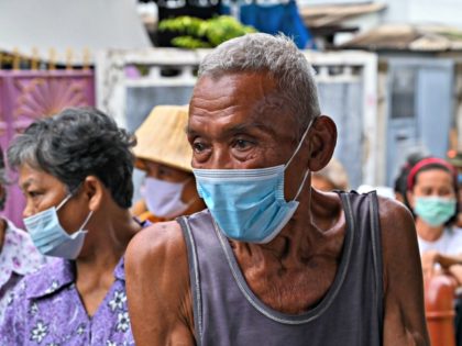 Elderly people line up for food and cash donations from Red Path Party, a Thai political organisation, at a district in Bangkok on April 25, 2020, as Thai citizens are affected by the restrictive measure related to the COVID-19 novel coronavirus. (Photo by Romeo GACAD / AFP) (Photo by ROMEO …