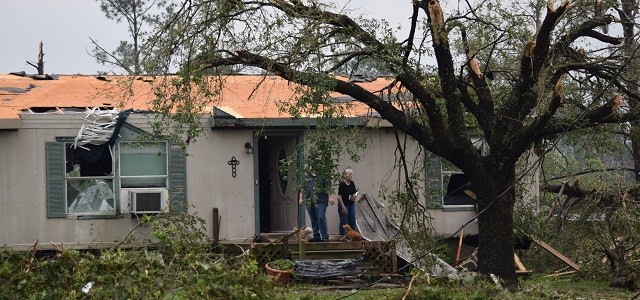 An Onalaksa couple stands outside their damaged home following the tornado that struck on April 22. (Photo: Lana Shadwick/Breitbart Texas)