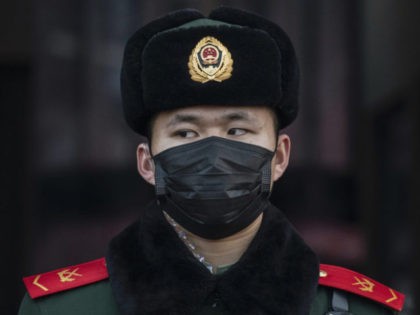 BEIJING, CHINA - JANUARY 22: A Chinese police officer wears a protective mask as he stands