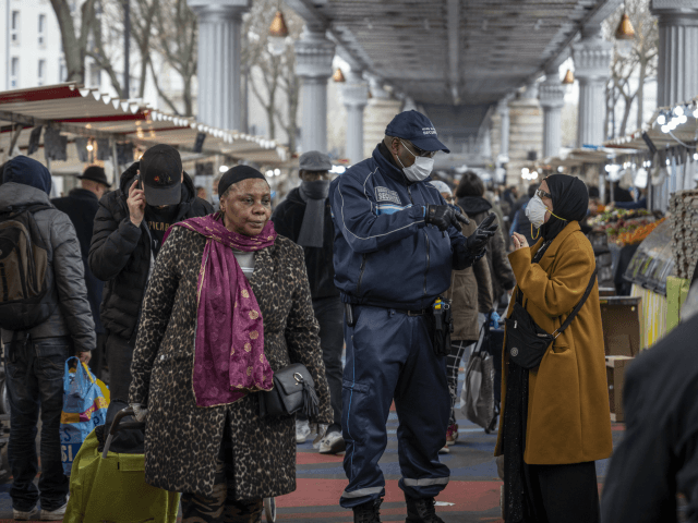 PARIS, FRANCE - MARCH 18: Shoppers visit a food market in a popular district of the 18th Arrondissement, where police advise the crowds on measures taken by the government to combat the spread of COVID-19 on March 18, 2020 in Paris, France. France imposed a nationwide lockdown to control the …