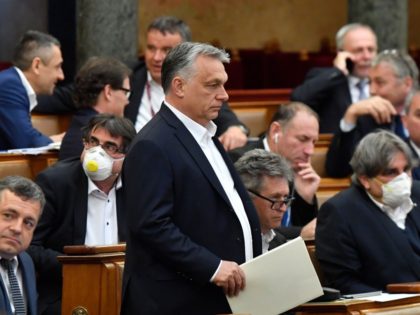 Hungarian Prime Minister Viktor Orban (C) walks near other representatives during a vote a