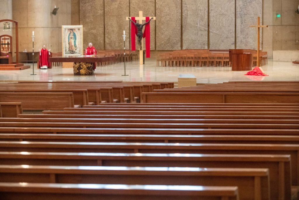 Archbishop Jose Gomez (R) and Father Brian Nunez (L) celebrate Good Friday liturgy in a nearly empty Cathedral of Our Lady of the Angels to guard against the coronavirus on April 10, 2020 in Los Angeles. -Service was held on video without parishioners. (BRIAN VAN DER BRUG/POOL/AFP via Getty Images)