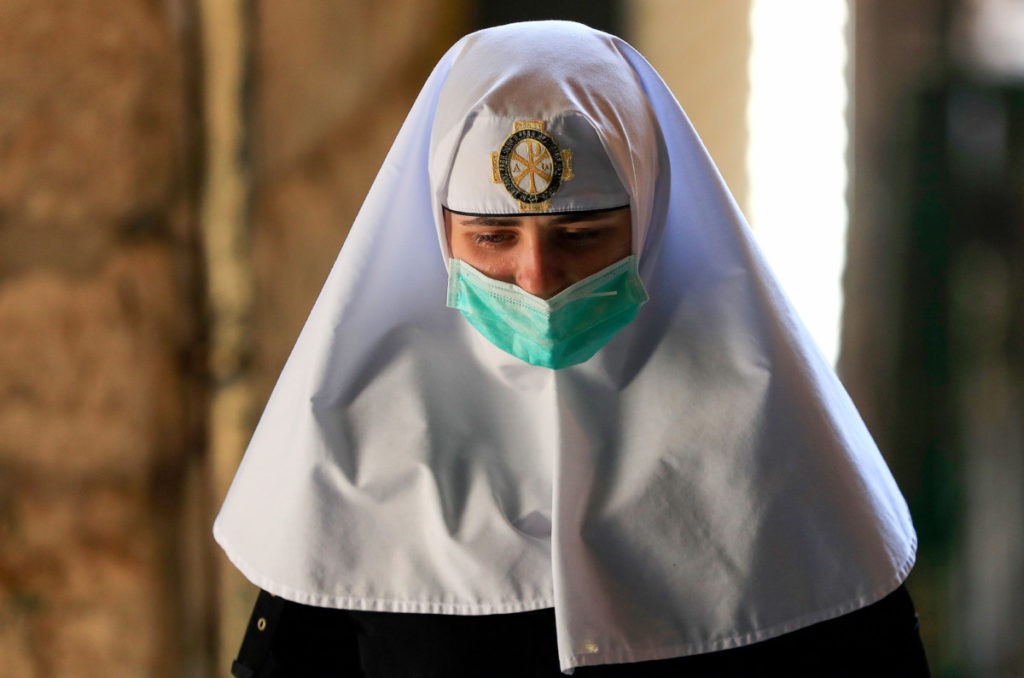 A nun walks along the Via Dolorosa (Way of Sorrow), ahead of Easter Sunday service amid the coronavirus disease (COVID-19) outbreak, in Jerusalem's Old City on April 12, 2020. - All cultural sites in the Holy Land are shuttered, regardless of their religious affiliation, as authorities seek to forestall the spread of the deadly respiratory disease. Christians will be prevented from congregating for the Easter service, whether this coming Sunday -- as in the case of Bitar and fellow Catholics -- or a week later on April 19 in the case of the Orthodox. (Photo by Emmanuel DUNAND / AFP) (Photo by EMMANUEL DUNAND/AFP via Getty Images)