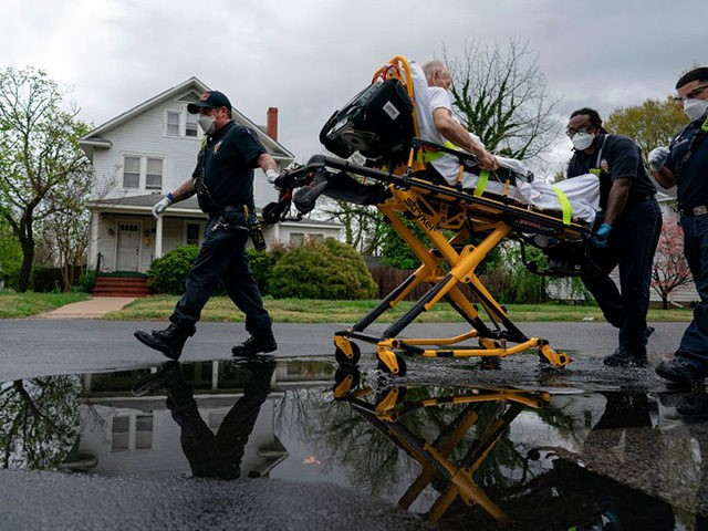 (FILES) In this file photo taken on April 13, 2020, firefighters and paramedics with Anne Arundel County Fire Department transport a patient experiencing COVID-19 symptoms in Glen Burnie, Maryland. (Photo by Alex Edelman / AFP) / RESTRICTED TO EDITORIAL USE (Photo by ALEX EDELMAN/AFP via Getty Images)