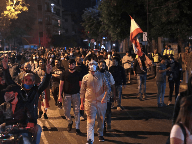 Lebanese demonstrators chant anti-government slogans while they walk through the streets of the capital Beirut on April 28, 2020, as anger over a spiralling economic crisis re-energised a months-old anti-government movement in defiance of a coronavirus lockdown. - Lebanese protesters confronted army troops for a second day as anger over …