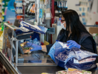 MILAN, ITALY - MARCH 11: A cashier, wearing a face mask, works at a supermarket on March 11, 2020 in Milan, Italy. The Italian Government has taken the unprecedented measure of a nationwide lockdown, limiting people to move only for work or health reasons, in an effort to fight the …