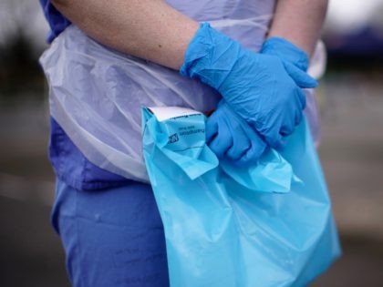 WOLVERHAMPTON, ENGLAND - MARCH 12: A NHS nurse holds a Coronavirus testing kit as she speaks to the media at a drive through Coronavirus testing site in a car park on March 12, 2020 in Wolverhampton, England. The National Health Service facility has been set up in a car park …