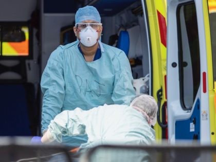 LONDON, UNITED KINGDOM - APRIL 10: NHS workers in PPE take a patient with an unknown condition from an ambulance at St Thomas' Hospital on April 10, 2020 in London, England. Public Easter events have been cancelled across the country, with the government urging the public to respect lockdown measures …