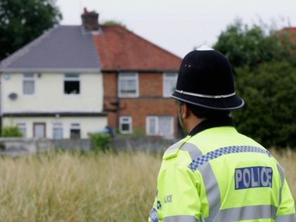 Birmingham, UNITED KINGDOM: A policeman stands guard 27 July 2005 at the back of a house on Heybarnes Rd in Birmingham after a man was arrested there in connection with the 21 July 2005 bombing attempts made on London's transport system. AFP PHOTO / CARL DE SOUZA. (Photo credit should …