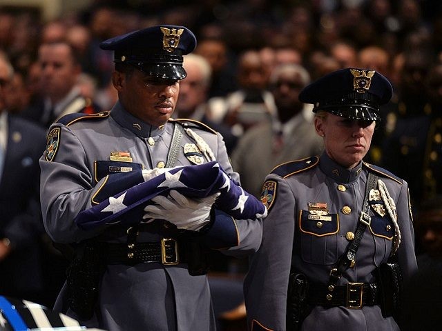BATON ROUGE, LA - JULY 25: A police honor guard carries an American flag during the funeral of Baton Rouge police corporal Montrell Jackson at the Living Faith Christian CenterJuly 25, 2016 in Baton Rouge, Louisiana. Jackson and multiple police officers were killed and wounded July 17, in a shooting …