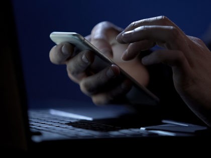 Scammer holds smartphone, cracks two-factor authentication, steals money online, stock foo