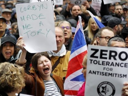 A woman holds up a placard declaring "Corbyn made me a Tory" as she joins protesters gathering for a demonstration organised by the Campaign Against Anti-Semitism outside the head office of the British opposition Labour Party in central London on April 8, 2018. Labour leader Jeremy Corbyn has been under …