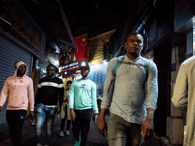 In this photo taken on March 1, 2018, people walk in the "Little Africa" district in Guangzhou, the capital of southern China's Guangdong province. - The commercial hub has long been a magnet for fortune-seeking Africans, but traders and students say they face unfavourable visa rules and increasingly heavy policing. …