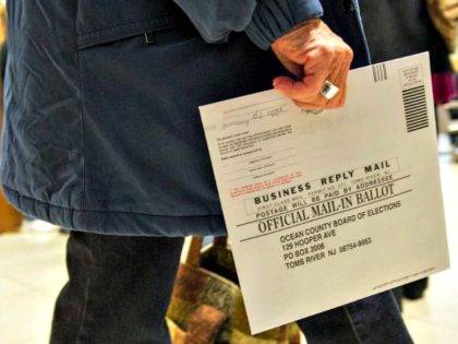 An Ocean County voter in Toms River, New Jersey, carries her completed ballot in an envelo