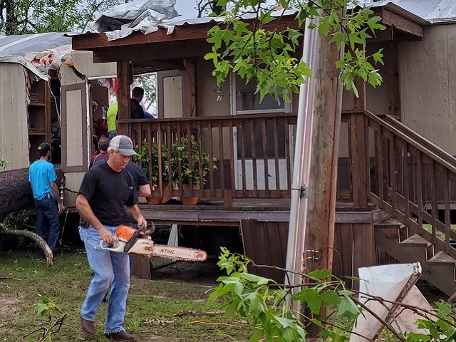 Onalaska Volunteer Fire Department rescuers work to cut away the flooring where a tree fell on a tornado victim. (Photo: Bob Price/Breitbart Texas)
