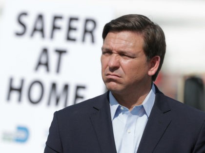 Florida Gov. Ron DeSantis listens during a news conference at a drive-through coronavirus