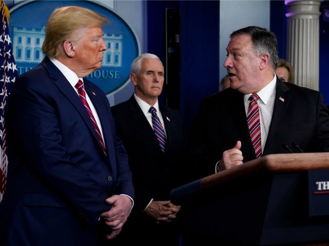 President Donald Trump, left, listens as Secretary of State Mike Pompeo speaks during a coronavirus task force briefing at the White House, Friday, March 20, 2020, in Washington. (AP Photo/Evan Vucci)