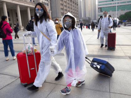 Passengers wearing face masks and rain coats to protect against the spread of new coronavirus walk outside of Hankou train station after of the resumption of train services in Wuhan in central China's Hubei Province, Wednesday, April 8, 2020. After 11 weeks of lockdown, the first train departed Wednesday morning …