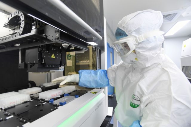 This photo taken on February 6, 2020 shows a laboratory technician working on samples from people to be tested for the new coronavirus at "Fire Eye" laboratory in Wuhan in China's central Hubei province. - BGI Group, a genome sequencing company based in southern China, said it opened on February …