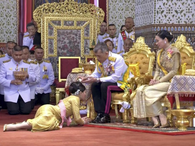 In this image made from video, Thailand’s King Maha Vajiralongkorn, center, and Queen Su