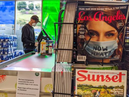 A patron wears a cap, face mask and gloves while shopping at the 365 Whole Foods Market in the Los Feliz neighborhood of Los Angeles Tuesday, March 31, 2020. A group of workers at Whole Foods, which is owned by Amazon, planned to stage a "sick out" Tuesday to demand …