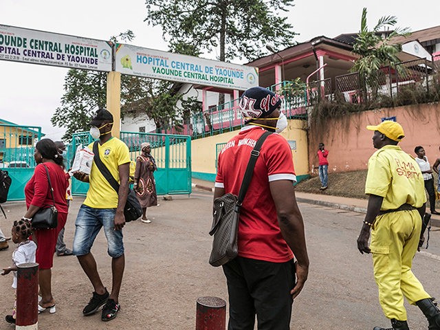 Some people wear masks as they walk by the entrance to the Yaounde General Hospital in Yao
