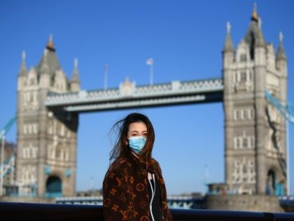 LONDON, ENGLAND - MARCH 22: A member of the public poses for a photo in front of Tower Bridge whilst wearing a protective mask on March 22, 2020 in London, England. Coronavirus (COVID-19) has spread to at least 188 countries, claiming over 13,000 lives and infecting more than 300,000 people. …