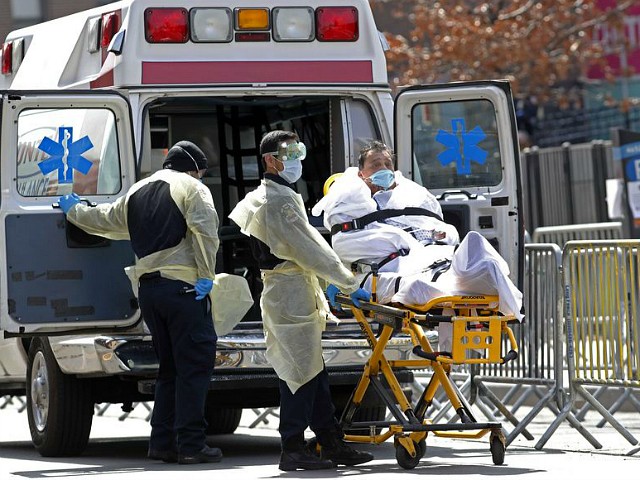 A patient is wheeled out of Elmhurst Hospital Center to a waiting ambulance, Tuesday, April 7, 2020, in the Queens borough of New York, during the current coronavirus outbreak. New York Gov. Andrew Cuomo said last week that as city hospitals fill up, some patients could be moved to other facilities in the state to ease the crunch on local medical centers. (AP Photo/Kathy Willens)