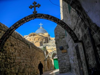 A monk walks near the Church of the Holy Sepulchre before the start of the Easter Sunday service amid the coronavirus disease (COVID-19) outbreak, in Jerusalem's Old City on April 12, 2020. - All cultural sites in the Holy Land are shuttered, regardless of their religious affiliation, as authorities seek …