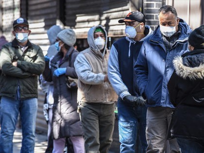 NEW YORK, NY - APRIL 1: People stand in line while wearing face masks in the Elmhurst neighborhood on April 1, 2020 in New York City. With more than 75,000 confirmed cases of COVID-19 and more than 1,000 deaths, New York City has become the epicenter of the outbreak in …