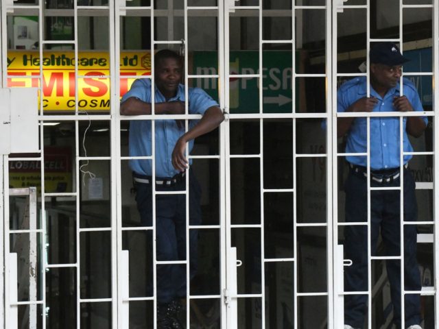 Private security guards watching behind the grills before the beginning of a curfew which