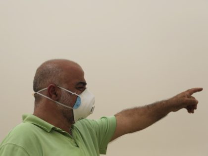 A Palestinian covers his face with a mask during a sandstorm in Jerusalem's Old City, Tuesday, Sept. 8, 2015. The unseasonal sandstorm has hit the Middle East, reducing visibility and sending hundreds to hospitals with breathing difficulties. (AP Photo/Hatem Moussa)