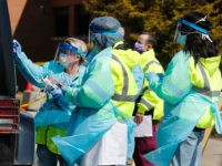 Healthcare workers test a person at a COVID-19 drive-thru testing site at Henry Ford West Bloomfield Hospital, Wednesday, March 25, 2020, in West Bloomfield, Mich. (AP Photo/Carlos Osorio)