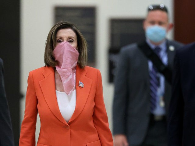 WASHINGTON, DC - APRIL 24: Wearing a scarf over her mouth and nose, Speaker of the House Nancy Pelosi (D-CA) is surrounded by security and staff as she arrives for her weekly news conference during the novel coronavirus pandemic at the U.S. Capitol April 24, 2020 in Washington, DC. President …