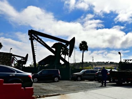 he oil derrick pumps in front of Curly's Cafe in Signal Hill, California on September 25, 2019. - The area in south Los Angeles County near Long Beach was a growing residential area before the 1921 discovery of the Long Beach oilfield leading to a landscape with so many oil …